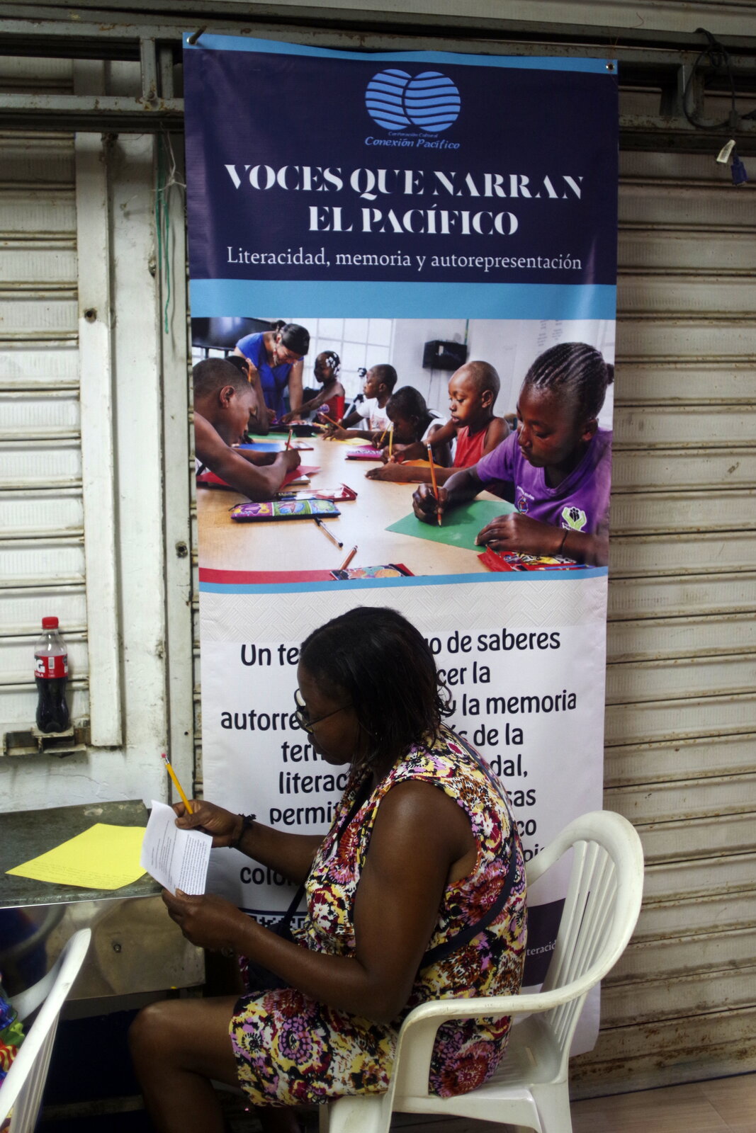 Participante junto al pendón del proyecto